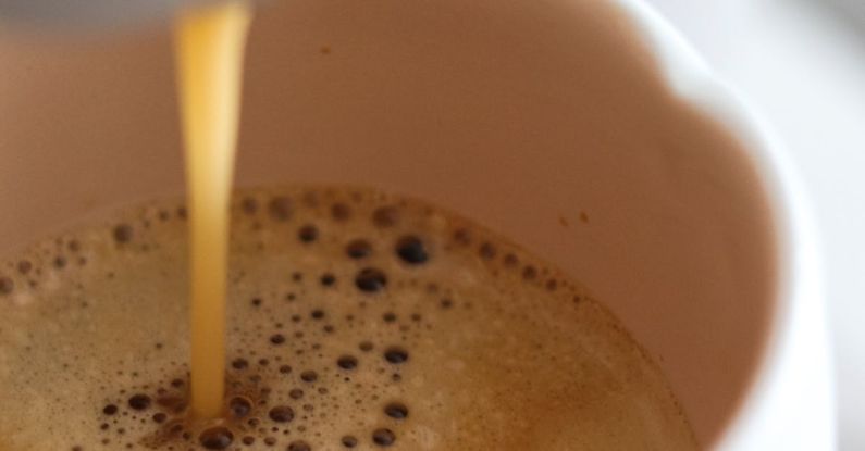 Coffee Maker - Close-up of Coffee Being Poured From a Coffee Machine into a Cup