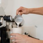 Coffee Maker - Person Pouring Milk on White Cup