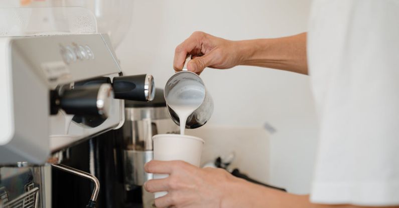 Coffee Maker - Person Pouring Milk on White Cup